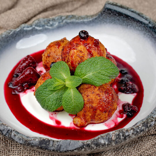 Papanași cu sos de smântână și vanilie și dulceață de afine